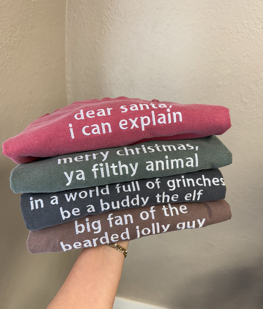 a hand holding a stack of t-shirts