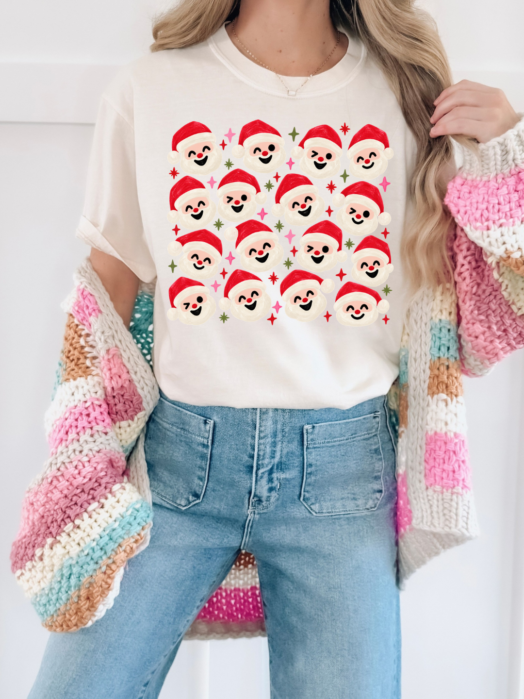 a woman wearing a sweater and a sweater with santa's faces on it