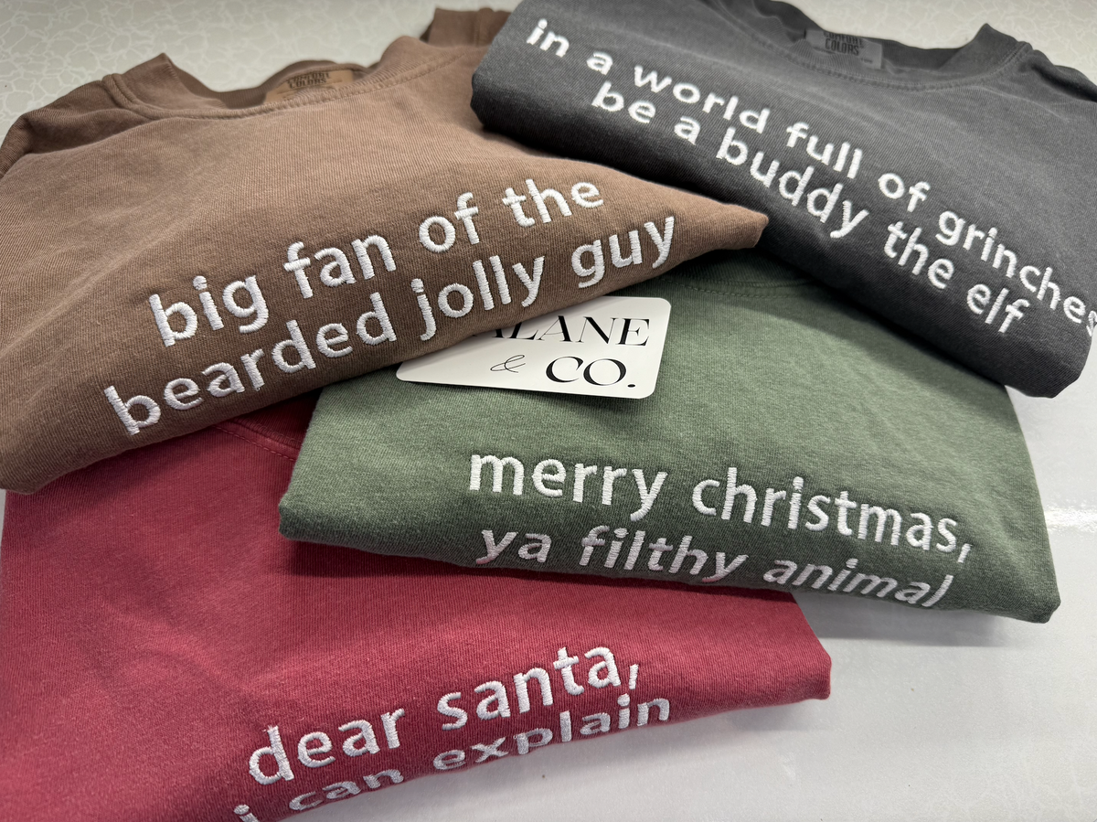 a group of folded shirts with white text on them